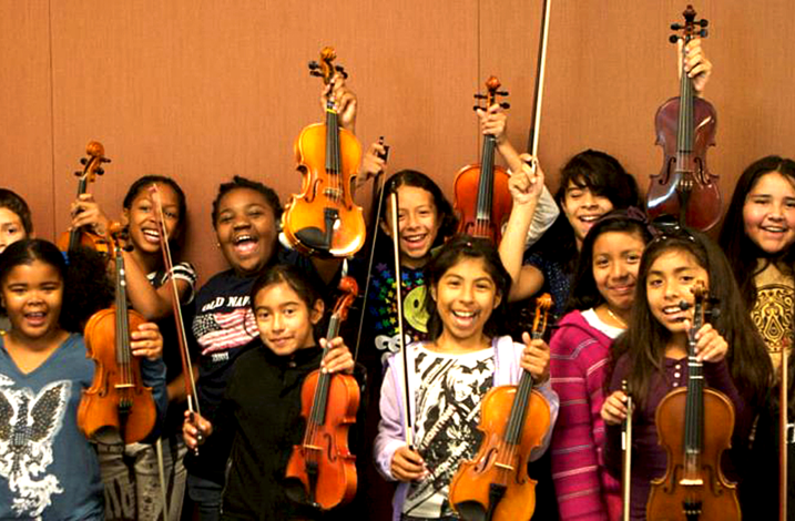 Young violin players showing their violins