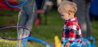Child Playing with Bubbles at walk for Kids 